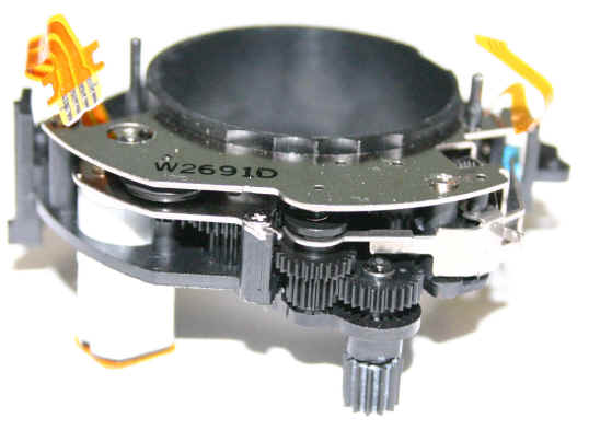 Micro motor des Canon EF 75-300 Objektivs. Oben befindet sich die Röhre mit Linse, die vom Motor bewegt wird. Der Mechanismus ist also in Bogenform um den Tubus herum aufgebaut. Foto electricstuff.co.uk