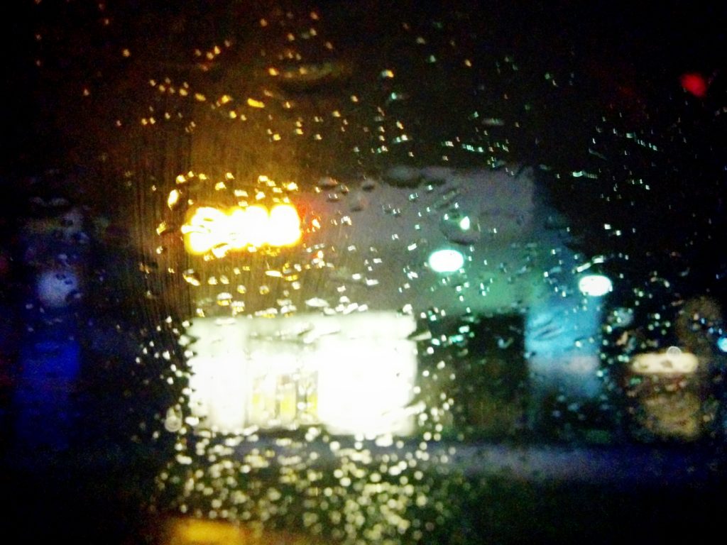 Frontscheibe im Regen vor einem Einkaufcenter.