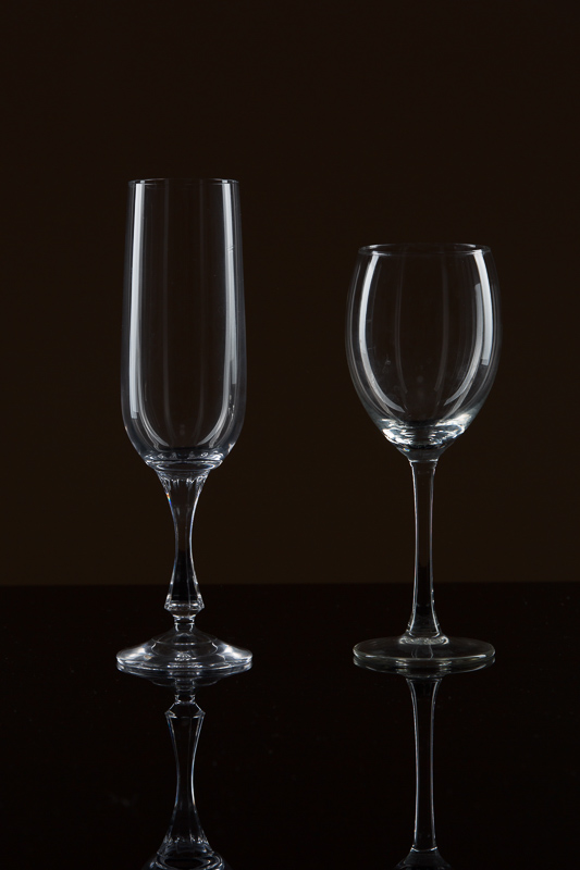 Gläser auf schwarzem Glas mit schwarzer Wand.