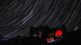 Beherrschen Sie das Fotografieren der Sternspuren. 5 Tipps, wie man Startrails fotografiert: Sternspuren über der Bergruine Zubštejn.