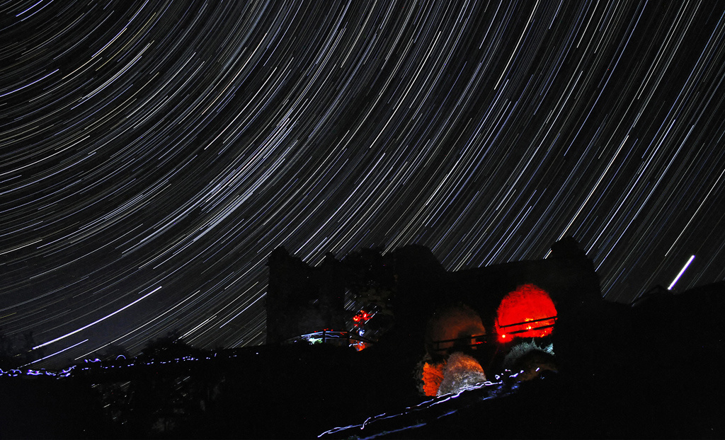 Beherrschen Sie das Fotografieren der Sternspuren. 5 Tipps, wie man Startrails fotografiert: Sternspuren über der Bergruine Zubštejn.