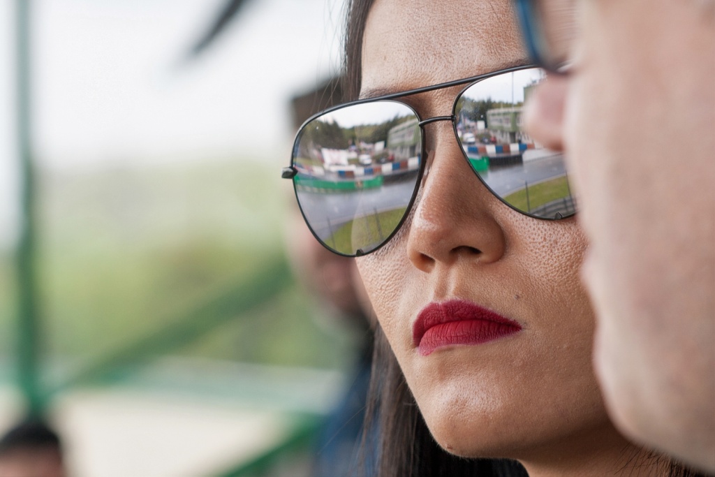 Sportfotografie: Grundlegende Tipps, wie man Sportevents fotografiert : Die Spiegelung in der Sonnenbrille habe ich dazu genutzt, um einen Teil der Rennbahn von der Zuschauerbühne zu erfassen.