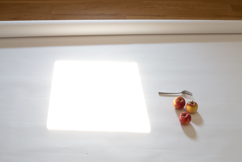 Stillleben fotografieren: Auf diesem Foto sieht man die “Hintergrundkulisse” für das künftige Bild mit dem Apfel und der Gabel.